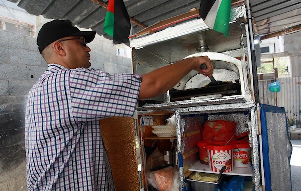 الفلسطيني داود البوجي (46 عاما) من غزة يبيع المعجنات باستخدام مخبز متنقل يسمى الست بنات ، في شوارع مخيم الشاطئ غرب مدينة غزة  11