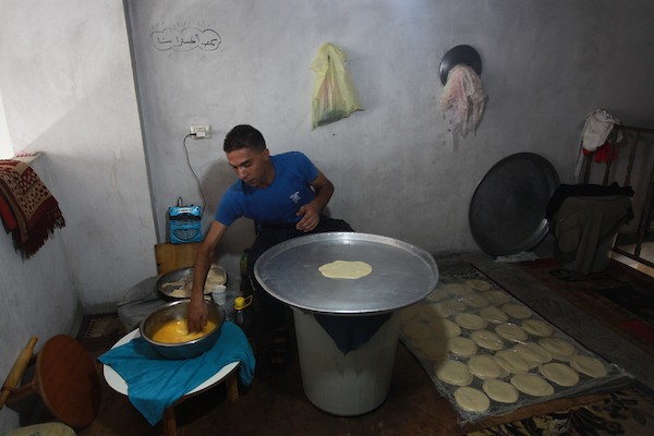 الشاب الفلسطيني أحمد علي ، 31 عامًا ، يصنع فطير مشلتت ، في متجره في مخيم الشاطئ ، في مدينة غزة  77.JPG