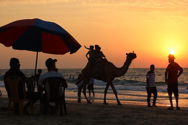 فلسطينيون يستمتعون بأوقاتهم على شاطئ البحر في مدينة دير البلح وسط قطاع غزة. 27
