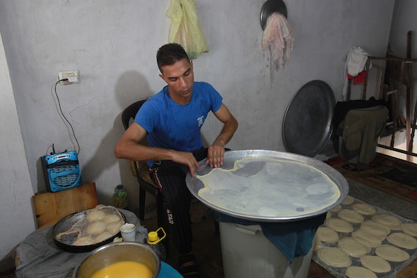 الشاب الفلسطيني أحمد علي ، 31 عامًا ، يصنع فطير مشلتت ، في متجره في مخيم الشاطئ ، في مدينة غزة  7.JPG