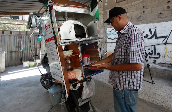 الفلسطيني داود البوجي (46 عاما) من غزة يبيع المعجنات باستخدام مخبز متنقل يسمى الست بنات ، في شوارع مخيم الشاطئ غرب مدينة غزة 5