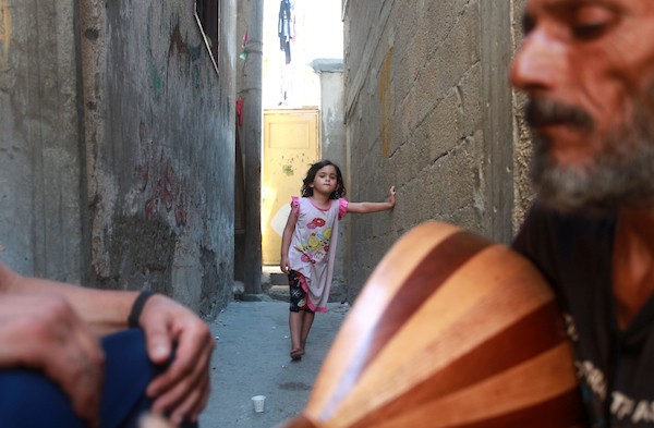 اللاجئ الفلسطيني كمال أبو غبن يعزف على آلة العود أثناء راحته في العمل 4