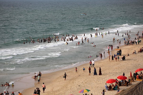 فلسطينيون يستمتعون بأوقاتهم على شاطئ البحر في مدينة دير البلح وسط قطاع غزة. 16