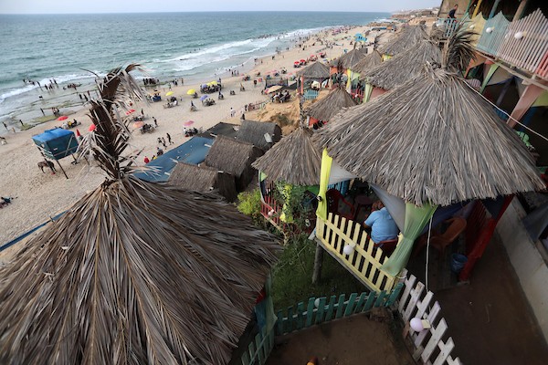 فلسطينيون يستمتعون بأوقاتهم على شاطئ البحر في مدينة دير البلح وسط قطاع غزة. 8