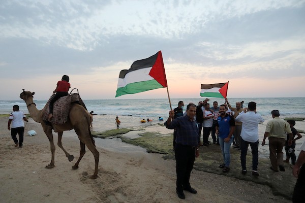 فلسطينيون يستمتعون بأوقاتهم على شاطئ البحر في مدينة دير البلح وسط قطاع غزة. 5