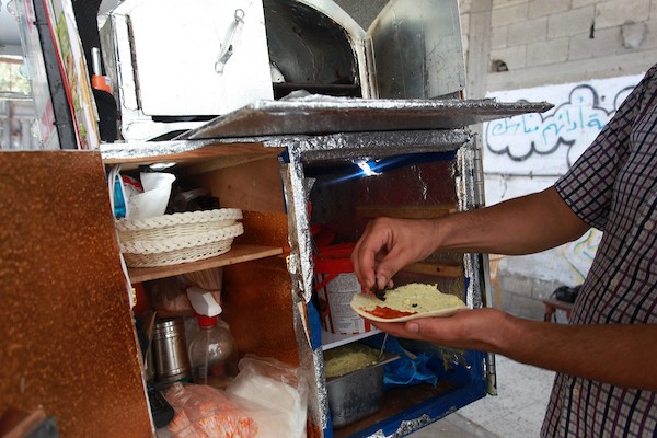 الفلسطيني داود البوجي (46 عاما) من غزة يبيع المعجنات باستخدام مخبز متنقل يسمى الست بنات ، في شوارع مخيم الشاطئ غرب مدينة غزة  12