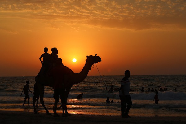 فلسطينيون يستمتعون بأوقاتهم على شاطئ البحر في مدينة دير البلح وسط قطاع غزة.