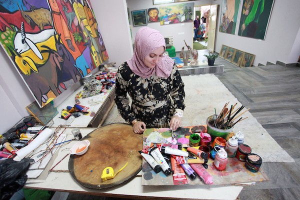 أقام الفنانان التشكيليان الفلسطينيان محمد الحواجري وزوجته دينا مطر معرضا للوحاتهما على سطح منزلهما في مخيم البريج وسط قطاع غزة  3