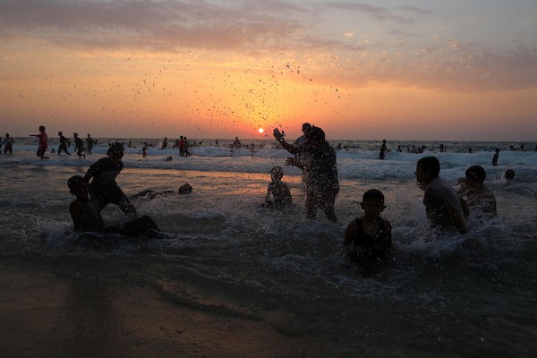 فلسطينيون يستمتعون بأوقاتهم على شاطئ البحر في مدينة دير البلح وسط قطاع غزة. 20