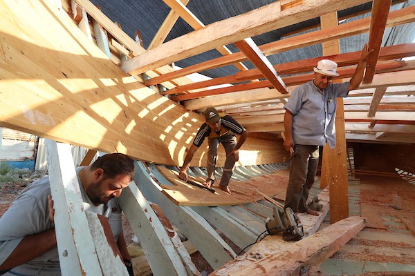 فلسطينيون يعملون على صناعة أكبر قارب صيد في خان يونس جنوب قطاع غزة بأدوات ومعدات بسيطة 48