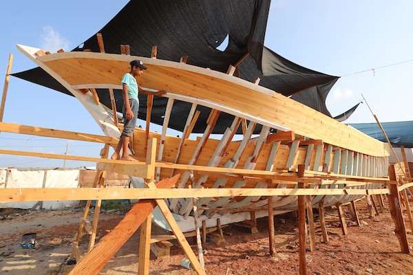 فلسطينيون يعملون على صناعة أكبر قارب صيد في خان يونس جنوب قطاع غزة بأدوات ومعدات بسيطة 1