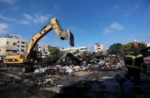 فلسطينيون يتفقدون آثار الحريق الذي التهم محالهم وبسطاتهم في سوق لبيع البضائع المستعملة في المنطقة الشرقية في مدينة نابلس 8