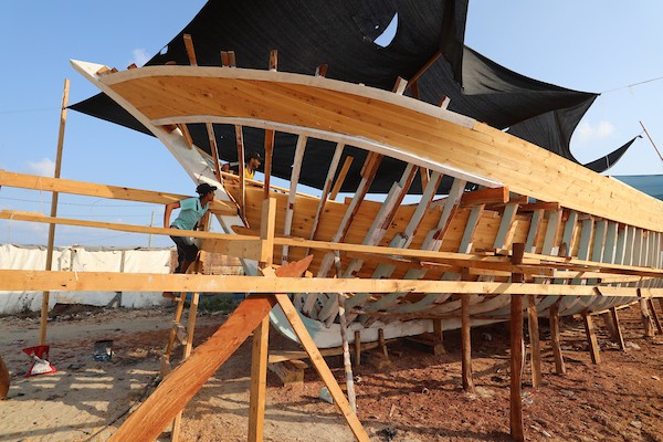 فلسطينيون يعملون على صناعة أكبر قارب صيد في خان يونس جنوب قطاع غزة بأدوات ومعدات بسيطة 53