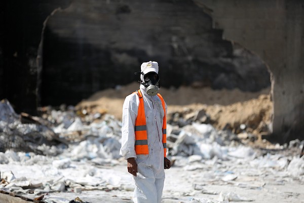 عمال يزيلون المخلفات الكيمائية والمبيدات الزراعية الناجمة عن القصف الإسرائيلي شمال قطاع غزة 
