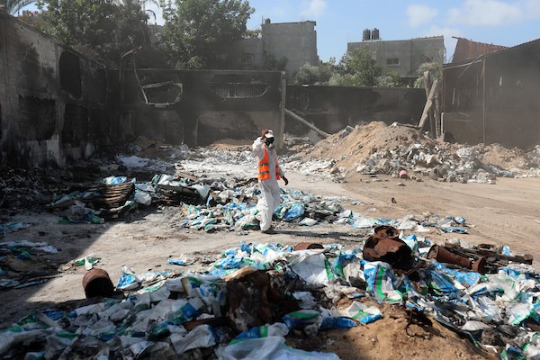 عمال يزيلون المخلفات الكيمائية والمبيدات الزراعية الناجمة عن القصف الإسرائيلي شمال قطاع غزة 