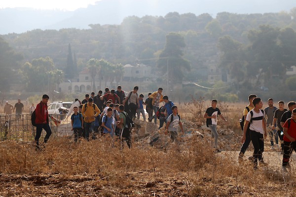 طلاب فلسطينيون يسيرون لمدارسهم بعد منع الجنود الاسرائيلية من عبورهم الطريق الرئيسي في قرية اللُبّن الشرقية بين رام الله ونابلس