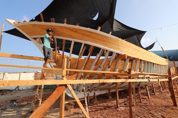 فلسطينيون يعملون على صناعة أكبر قارب صيد في خان يونس جنوب قطاع غزة بأدوات ومعدات بسيطة