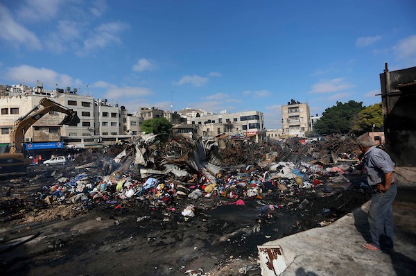 فلسطينيون يتفقدون آثار الحريق الذي التهم محالهم وبسطاتهم في سوق لبيع البضائع المستعملة في المنطقة الشرقية في مدينة نابلس 1