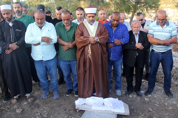 فلسطينيون يؤدون الصلاة على بقايا الرفات من القبور التي هدمتها قوات الاحتلال الإسرائيلي في المقبرة اليوسفية في القدس، قبل إعادة دفنها مرة أخرى