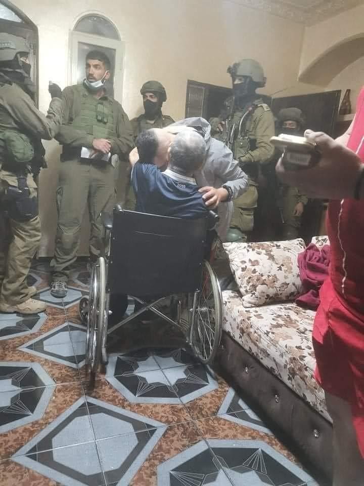 الشاب عهد يوسف الشوملي يودع والده المقعد قبل اعتقاله فجر اليوم من منزله في بيت ساحور.