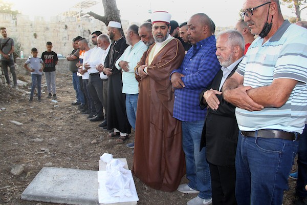 فلسطينيون يؤدون الصلاة على بقايا الرفات من القبور التي هدمتها قوات الاحتلال الإسرائيلي في المقبرة اليوسفية في القدس، قبل إعادة دفنها مرة أخرى