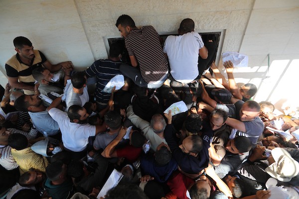 مواطنون فلسطينيون ينتظرون أمام مقر الغرفة التجارية للتسجيل من اجل العمل في إسرائيل، في دير البلح وسط قطاع غزة(28)