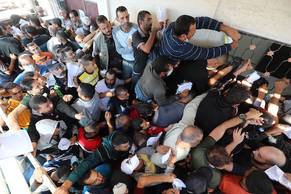 مواطنون فلسطينيون ينتظرون أمام مقر الغرفة التجارية للتسجيل من اجل العمل في إسرائيل، في دير البلح وسط قطاع غزة(27)