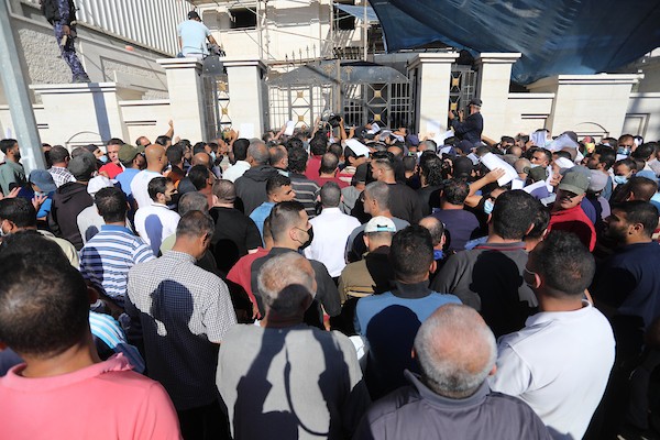 مواطنون فلسطينيون ينتظرون أمام مقر الغرفة التجارية للتسجيل من اجل العمل في إسرائيل، في دير البلح وسط قطاع غزة(31)