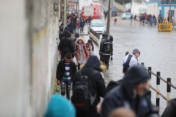 طلاب مدارس الأونروا يسيرون في شارع غمرته المياه وسط الأمطار الغزيرة في مدينة غزة (73)