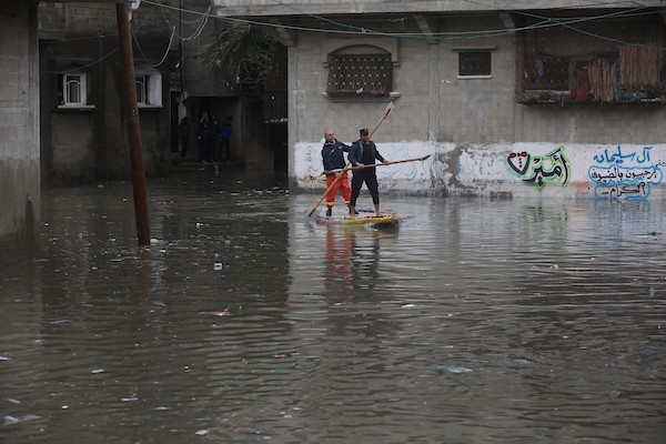 الدفاع المدني الفلسطيني ينتشل سكان من شارع غمرته مياه الأمطار ، في مخيم جباليا للاجئين الفلسطينيين شمال قطاع غزة 