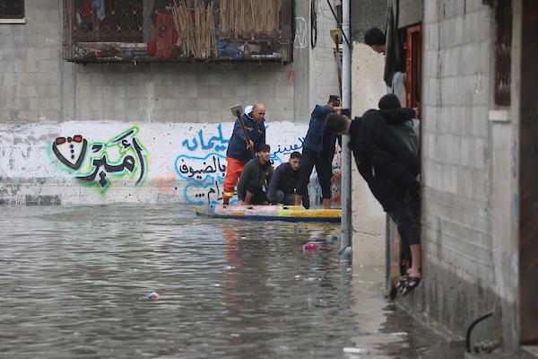 الدفاع المدني الفلسطيني ينتشل سكان من شارع غمرته مياه الأمطار ، في مخيم جباليا للاجئين الفلسطينيين شمال قطاع غزة 