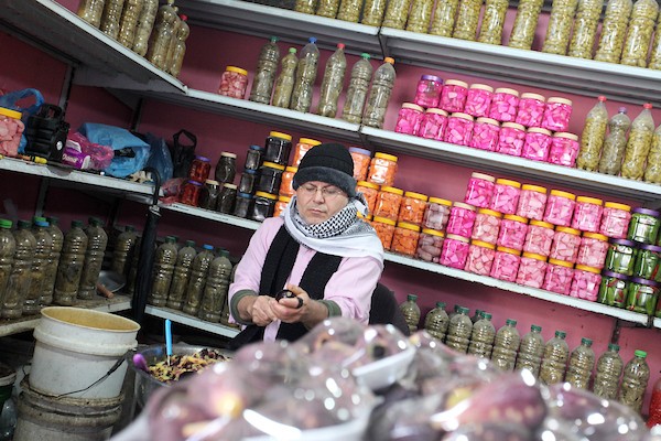  أمين أبو الكاس يحضر الخضار للطبخ في متجره في سوق فراس الشعبي في مدينة غزة 