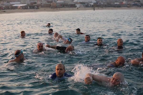 عشاق السباحة من كبار السن يمارسون هوايتهم على شاطئ بيت لاهيا في مربعانية الشتاء