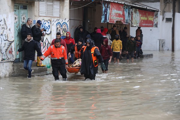 الدفاع المدني الفلسطيني ينتشل سكان من شارع غمرته مياه الأمطار ، في مخيم جباليا للاجئين الفلسطينيين شمال قطاع غزة 