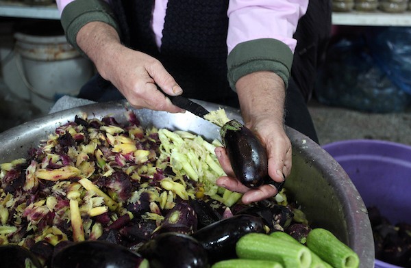  أمين أبو الكاس يحضر الخضار للطبخ في متجره في سوق فراس الشعبي في مدينة غزة 