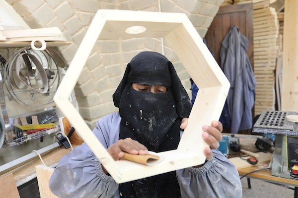 سيدات فلسطينيات يُبدعن بصنع الهدايا الخشبية في منجرة لبيعها بيوم المرأة العالمي.jpg