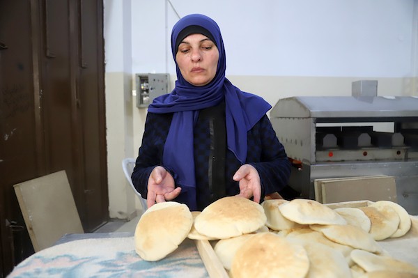 الفلسطينية أم محمد أبو العيش تحضر الخبز في مخبزها