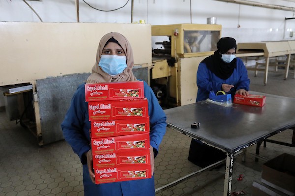 سيدات فلسطينيات يعملن داخل مصنع للمنتجات الغذائية في دير البلح وسط القطاع