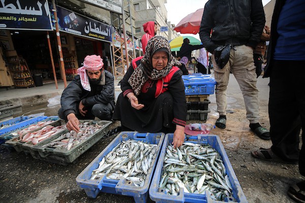 المسنة الفلسطينية أم جميل الأقرع من دير البلح وسط قطاع غزة تشتري الأسماك من الحسبة لتبيعها في السوق، لتعيل أسرتهامع احتفال العالم بيوم المرأة العالمي.