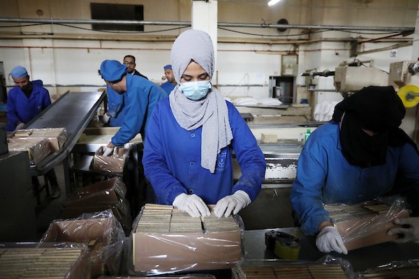 سيدات فلسطينيات يعملن داخل مصنع للمنتجات الغذائية في دير البلح وسط القطاع