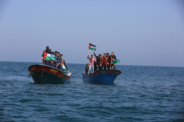 فلسطينيون يشاركون في مسير بحري بمناسبة يوم الأرض في البحر المتوسط في مدينة خانيونس جنوب قطاع غزة1.jpg