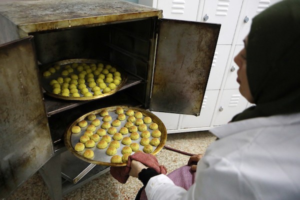 سيدات فلسطينيات يجهزن حلوى المعمول قبل عيد الفطر في مدينة الخليل