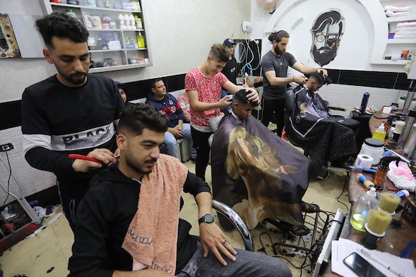 الفلسطينيون يقصون شعورهم داخل محل لتصفيف الشعر في مدينة خانيونس استعدادا لعيد الفطر 5.jpg