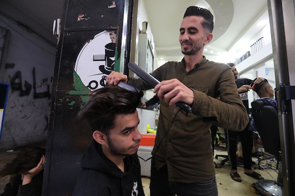 الفلسطينيون يقصون شعورهم داخل محل لتصفيف الشعر في مدينة خانيونس استعدادا لعيد الفطر 13.jpg