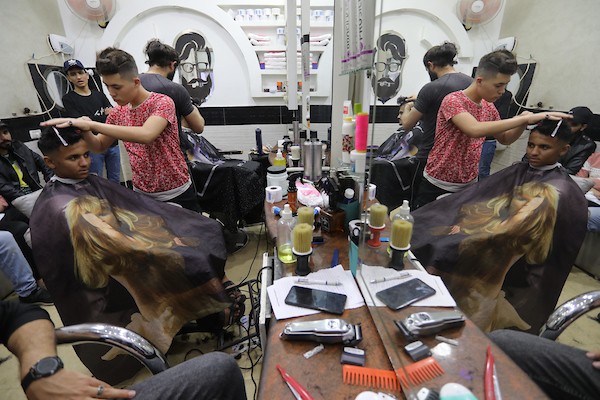 الفلسطينيون يقصون شعورهم داخل محل لتصفيف الشعر في مدينة خانيونس استعدادا لعيد الفطر 4.jpg