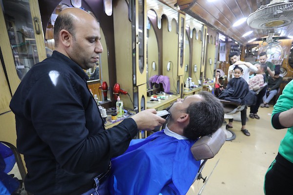 الفلسطينيون يقصون شعورهم داخل محل لتصفيف الشعر في مدينة خانيونس استعدادا لعيد الفطر 10.jpg