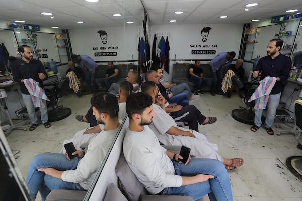 الفلسطينيون يقصون شعورهم داخل محل لتصفيف الشعر في مدينة خانيونس استعدادا لعيد الفطر 8.jpg