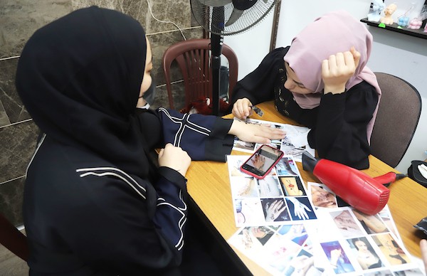 نساء فلسطينيات ينقشن الحنة استعدادا لعيد الفطر في مدينة غزة
