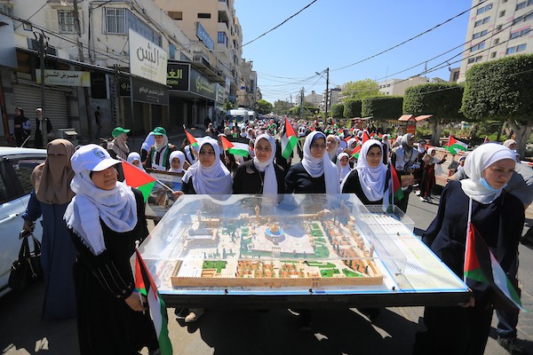فلسطينيات يشاركن في مسير الأعلام الفلسطينية خلال انطلاق مخيمات مواكب سيف القدس القرآنية في مدينة غزة 16.jpg