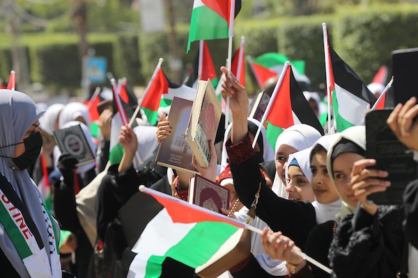 فلسطينيات يشاركن في مسير الأعلام الفلسطينية خلال انطلاق مخيمات مواكب سيف القدس القرآنية في مدينة غزة 14.jpg
